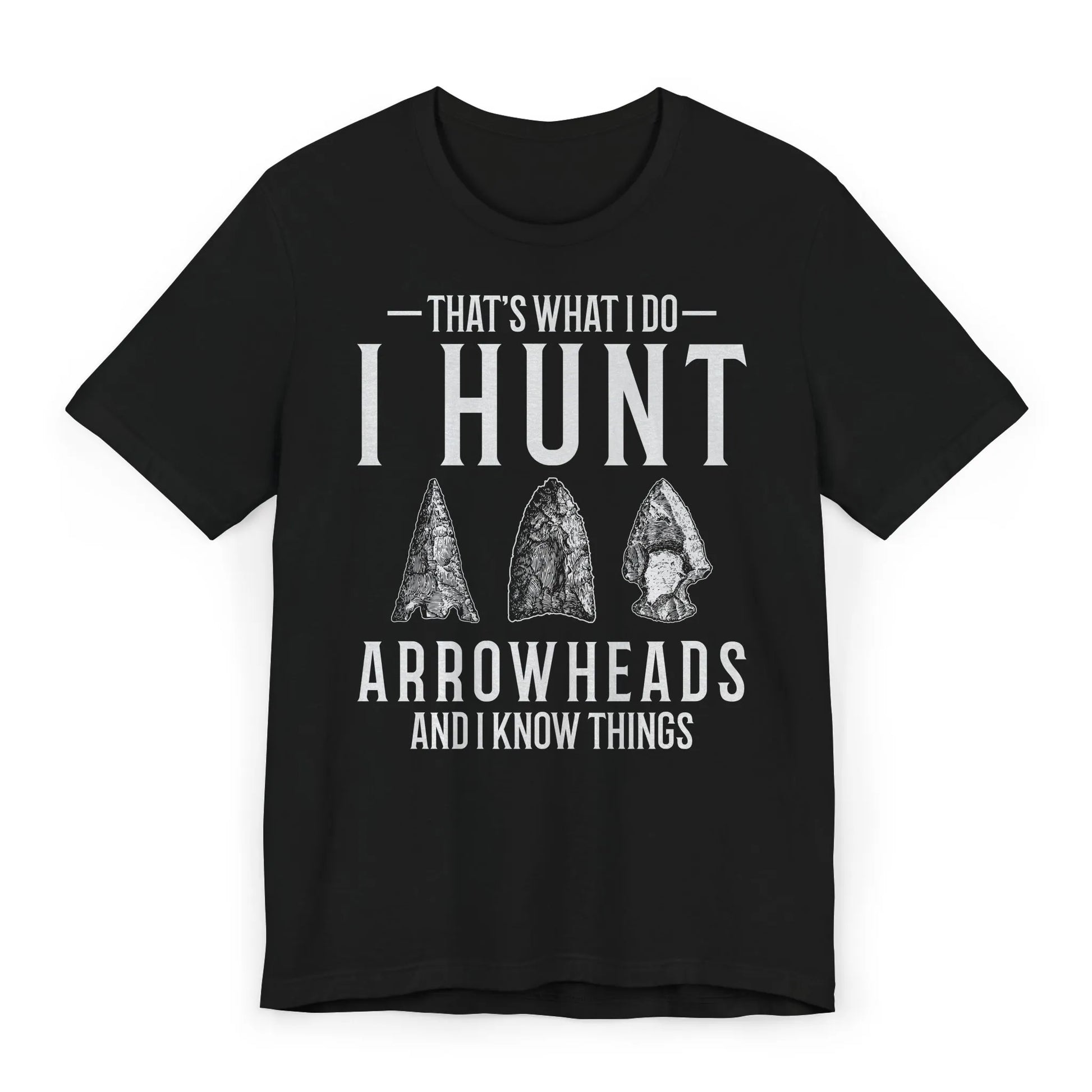 Flatlay image of black T-shirt with “That’s What I Do, I Hunt Arrowheads and I Know Things” quote and arrowhead graphics