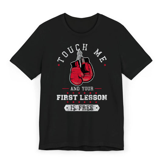 Flat lay of a boxing shirt with red gloves and quote "Touch Me and Your First Lesson Is Free."