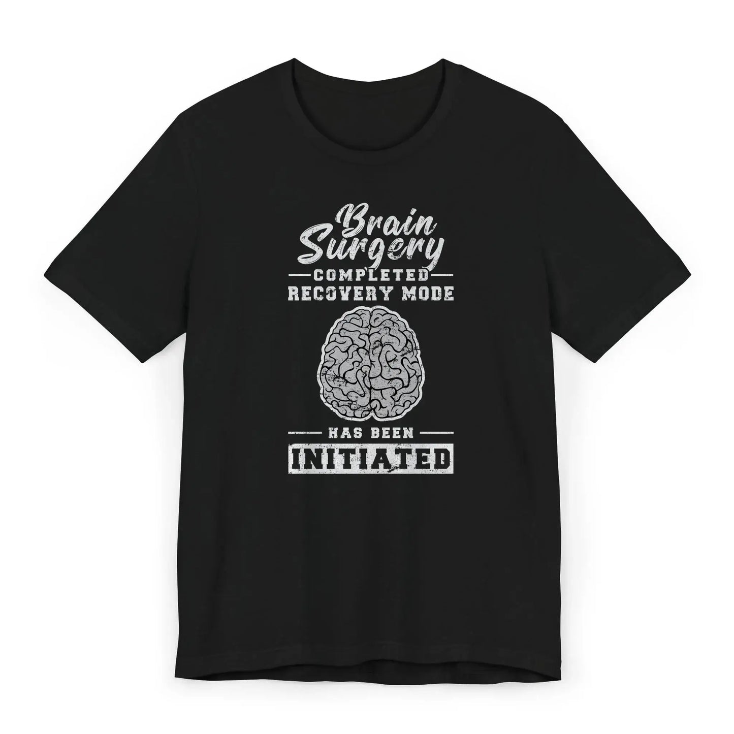 Flat lay of brain surgery recovery shirt with brain graphic and quote “Recovery Mode Has Been Initiated.”