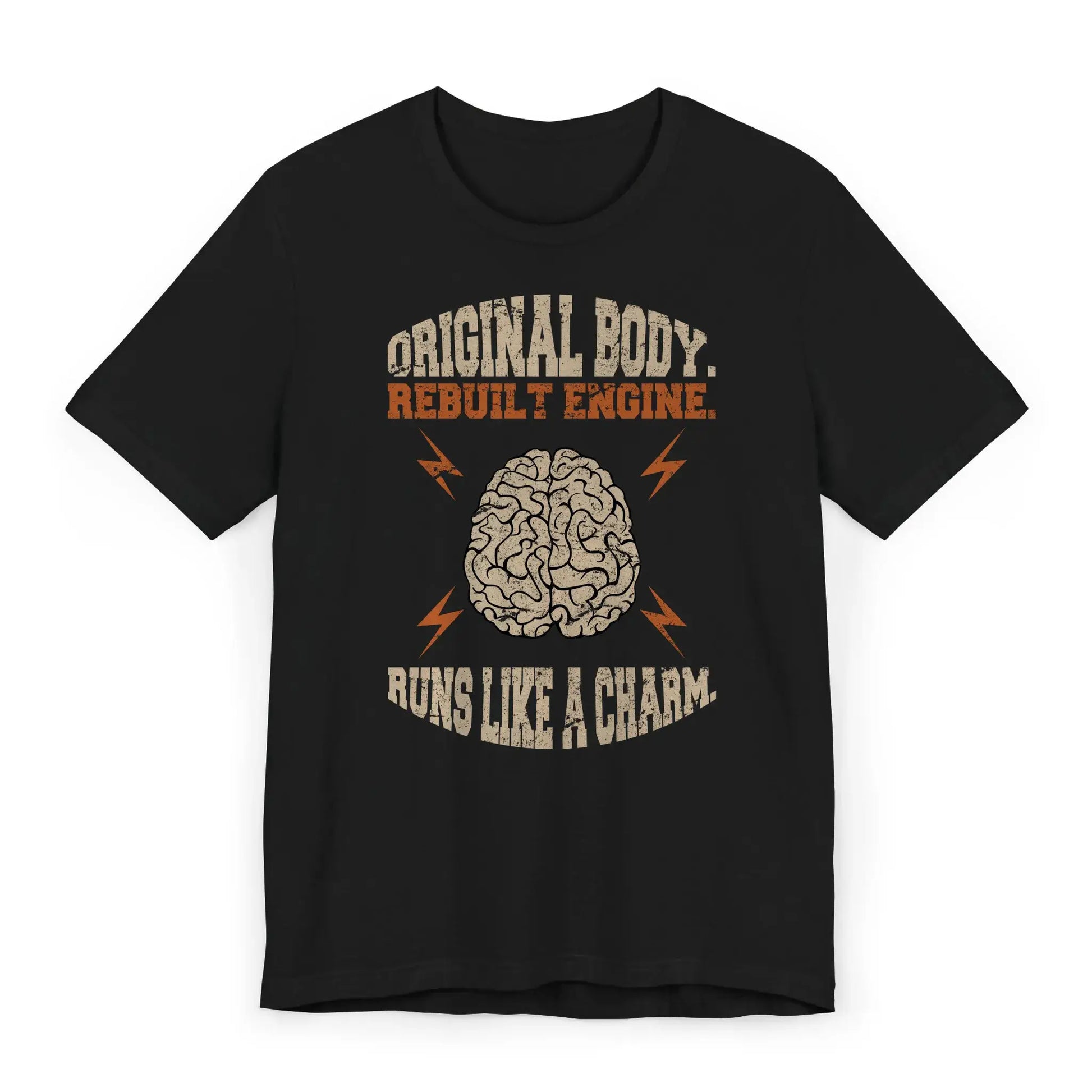 Flat lay of brain surgery recovery shirt with quote “Original Body. Rebuilt Engine. Runs Like a Charm.”