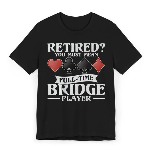 Flat lay of bridge player shirt with quote “Retired? You Must Mean Full-Time Bridge Player” and card suit symbols.